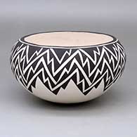 A black-on-white bowl decorated with a lightning bolt geometric design
 by Dolores Lewis of Acoma