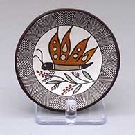 A small polychrome plate decorated with a butterfly, plant, fine line and geometric design
 by Rebecca Lucario of Acoma