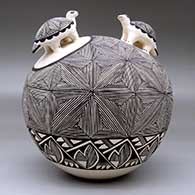A black-on-white seed pot with two turtle appliques and the whole decorated with a fine line snowflake and geometric design, click or tap to see a larger version