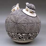 A black-on-white seed pot with two turtle appliques and the whole decorated with a fine line snowflake and geometric design, click or tap to see a larger version
