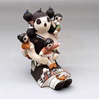A sitting grandmother storyteller figure with three children, birds, butterfly, kitten and lady bug
 by Judy Lewis of Acoma