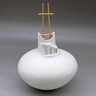 A white seed jar with a short neck and cut opening with a sculpted pueblo wall and kiva ladder
 by Wilfred Garcia of Acoma