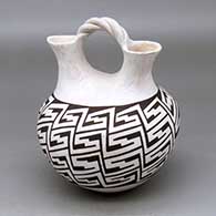 A black on white wedding vase with a twisted bridge and decorated with a locks and keys geometric design
 by Grace Chino of Acoma