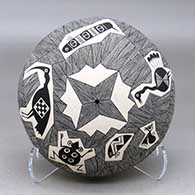 A black on white seed pot decorated with a fineline design surrounding Mimbres birds, bugs and creatures
 by Delores Aragon Juanico of Acoma