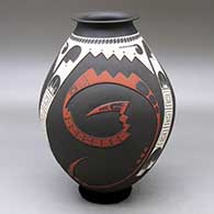 A polychrome jar with a rolled lip and decorated with a three panel lightly carved, sgraffito and painted sickle and geometric design
 by Roberto Olivas of Mata Ortiz and Casas Grandes