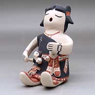 A sitting grandmother storyteller figure with two children, click or tap to see a larger version