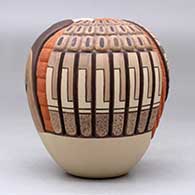A polychrome seed pot decorated with a carved and painted katsina, sunface, ear of corn and geometric design, click or tap to see a larger version