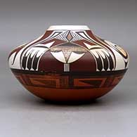 A low shouldered polychrome jar decorated with a four-panel bird element and geometric design above the shoulder and an eight-panel geometric design below the shoulder, click or tap to see a larger version