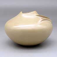 A buff bowl with an organic opening and a carved ear-of-corn applique, click or tap to see a larger version