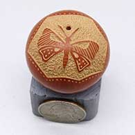 A miniature red seed pot decorated with a sgraffito butterfly and geometric design
 by Glendora Fragua of Jemez