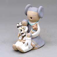 A sitting grandmother storyteller figure with four children, including a koshare and a mudhead child
 by Stella Teller of Isleta