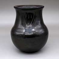 A polished black jar with a single bear paw imprint
 by Joy Cain of Santa Clara