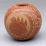 A red seed pot with a sgraffito two-panel turtle, quail, feather, rainbow and geometric design
 by Mae Tapia of Santa Clara