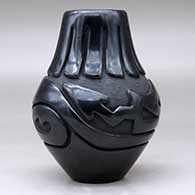 A black jar carved with an avanyu and ring of feathers design, click or tap to see a larger version