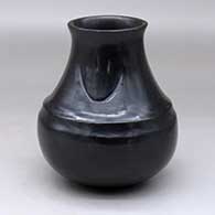 A black double-shouldered jar decorated with two bear paw imprints on the neck
 by Sharon Naranjo Garcia of Santa Clara