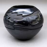 A black jar carved with an avanyu and geometric design around and above the shoulder
 by Mary Cain of Santa Clara
