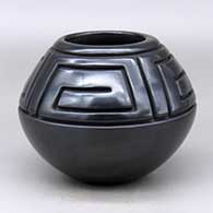 A black jar decorated with a four panel carved geometric design above the shoulder
 by Cliff Roller of Santa Clara