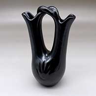 A polished black wedding vase with a twisted bridge and decorated with two bear paw imprints
 by Legoria Tafoya of Santa Clara