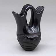 A small black wedding vase carved around the body with an avanyu design
 by Jane Baca of Santa Clara