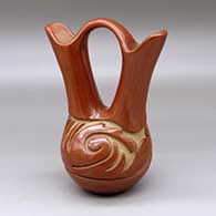 A red wedding vase carved around the body with a stylized avanyu design
 by Teresita Naranjo of Santa Clara