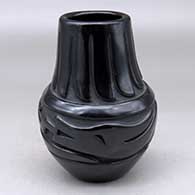 A black vase decorated with a carved avanyu, ring of feathers and geometric design
 by Elizabeth Naranjo of Santa Clara