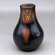 A black vase with sienna spots and a three panel sgraffito yeibichai and geometric design
 by Grace Medicine Flower of Santa Clara