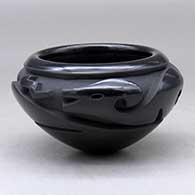 A highly polished black bowl carved with an avanyu design around the shoulder
 by Effie Garcia of Santa Clara