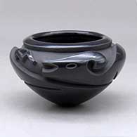 A black bowl carved around the shoulder with an avanyu design
 by Effie Garcia of Santa Clara