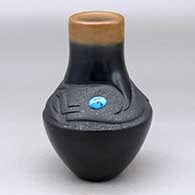 Click for a larger view A black and micaceous black vase with a sienna rim, an inlaid turquoise and a lightly carved avanyu design above the shoulder
by Dora Tse Pe of San Ildefonso