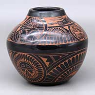 A black on red jar decorated with a four-panel sgraffito medallion, dancer, avanyu, feather and geometric design
 by Tom Tapia and Sue Tapia of Ohkay Owingeh and Laguna