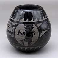 A black jar decorated with a sgraffito pueblo dancer, feather, pueblo and geometric design
 by Tom Tapia of Ohkay Owingeh