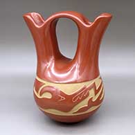 A red wedding vase decorated with a carved avanyu design around the shoulder
 by LuAnn Tafoya of Santa Clara