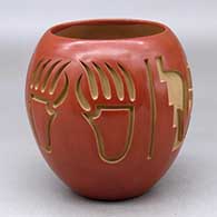 A red jar decorated with a four panel carved bear paw, kiva step, arrowhead and geometric design
 by Anna Archuleta of Santa Clara