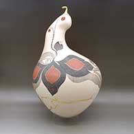 A large, lidded sculptural piece decorated with a lightly carved, sgraffito and painted flower, serpent and geometric design, click or tap to see a larger version