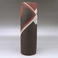 A tall polychrome cylinder decorated with a spiral and fineline flowing geometric design, click or tap to see a larger version