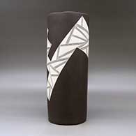 A white on brown cylinder with an organic rim and decorated with a fineline and geometric design, click or tap to see a larger version