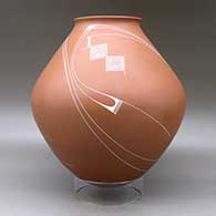 A white on red jar with a recurved lip and decorated with a flowing geometric design, click or tap to see a larger version