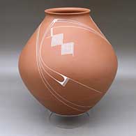 A white on red jar with a recurved lip and decorated with a flowing geometric design
 by Diego Valles of Mata Ortiz and Casas Grandes