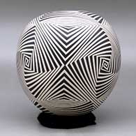 A black on beige jar decorated with a four panel spiraling geometric design, click or tap to see a larger version