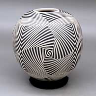 A black on beige jar decorated with a four panel spiraling geometric design
 by Rodrigo Perez of Mata Ortiz and Casas Grandes
