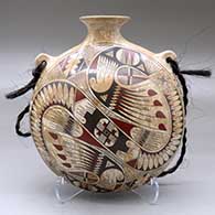 A polychrome mixed clay canteen decorated with a feather, bird element and geometric design on the front and a checkerboard geometric design on the back
 by Lupe and Rey Rodriguez of Mata Ortiz and Casas Grandes