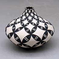 A black on white tear drop jar decorated with a pumpkin seed snowflake and geometric design
 by Dorothy Torivio of Acoma