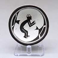 A small shallow black on white bowl decorated inside with a Mimbres man and geometric design
 by Emma Lewis of Acoma