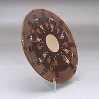 A polychrome round tile decorated with a Night Chant Dancers design, click or tap to see a larger version