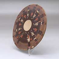 A polychrome round tile decorated with a Night Chant Dancers design, click or tap to see a larger version