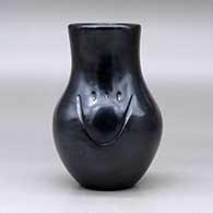 A black vase carved with two bear paw imprints, click or tap to see a larger version