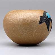 A small golden micaceous bowl decorated with a sgraffito and painted black bear with an inlaid turquoise, click or tap to see a larger version