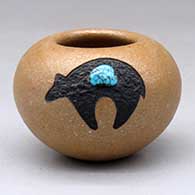 A small golden micaceous bowl decorated with a sgraffito and painted black bear with an inlaid turquoise
 by Russell Sanchez of San Ildefonso