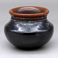 A black jar with a recurved sienna rim, two strands of inlaid heishi beads and a four-panel geometric design above the shoulder
 by Erik Fender of San Ildefonso