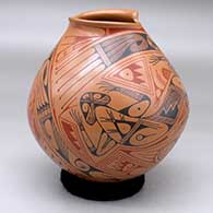 A polychrome jar with a geometric cut opening and decorated with a two panel lizard and geometric design
 by Pilo Mora of Mata Ortiz and Casas Grandes